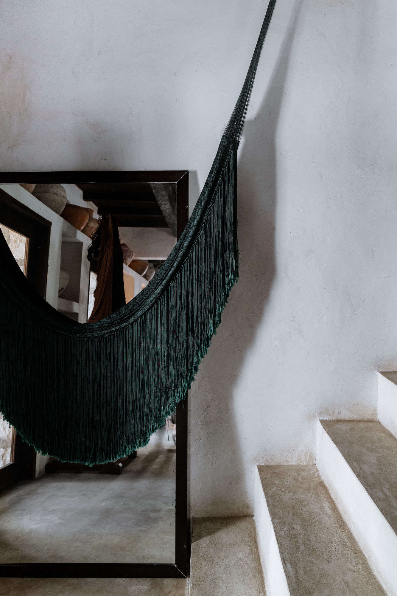 Fringed hammocks hang inside and out. They