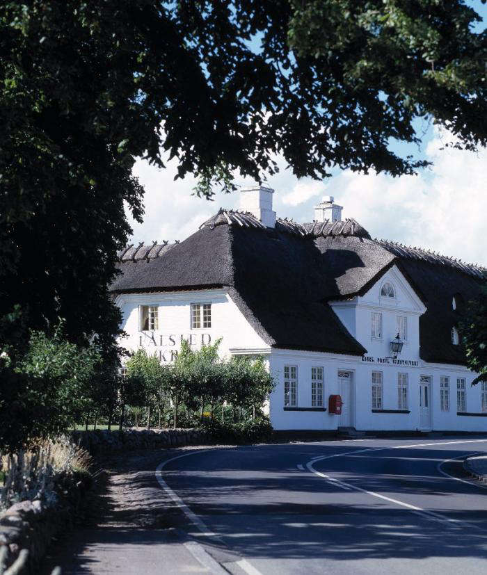 A steep roof and white exterior welcome visitors.