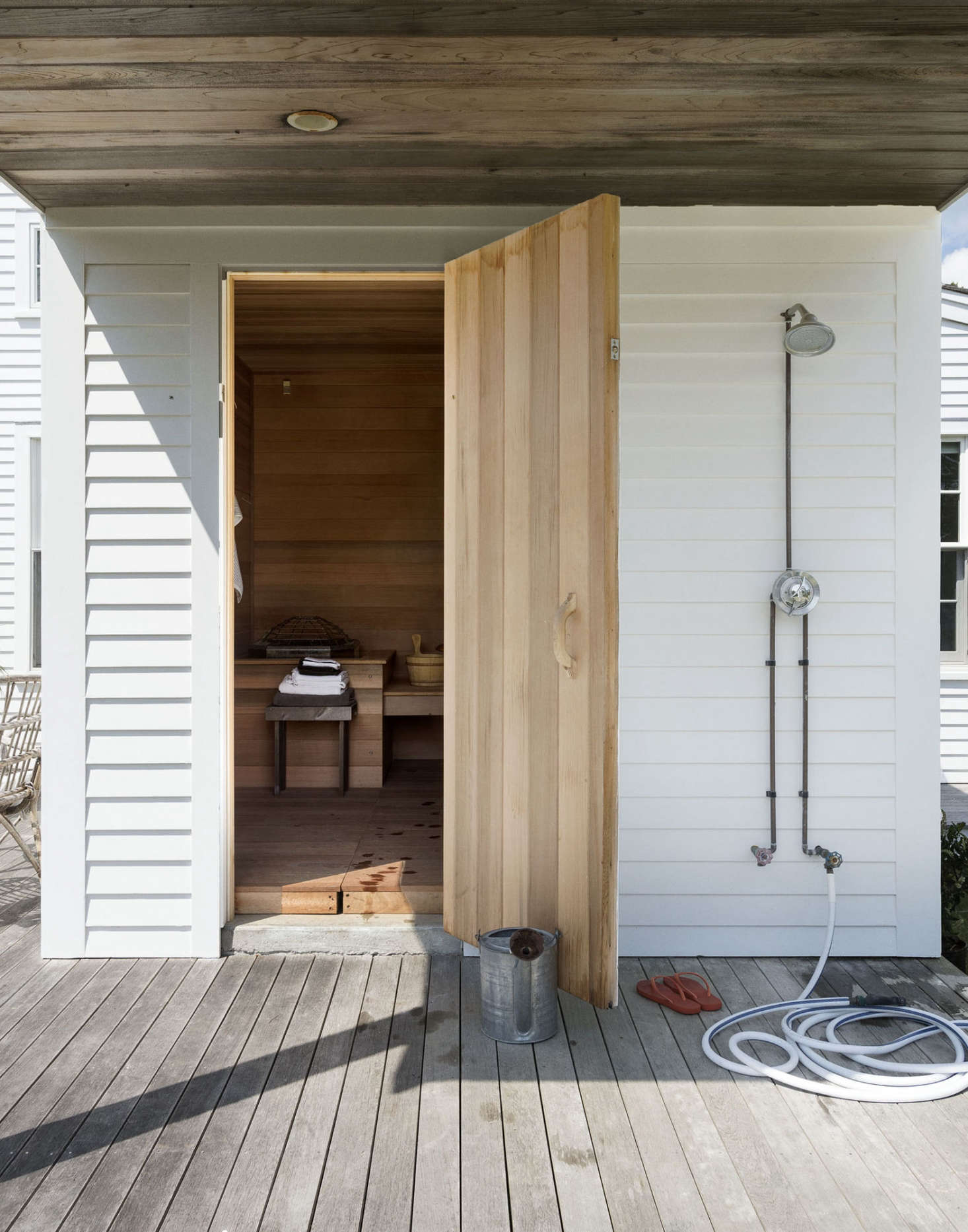 A Maine summer necessity: an unfussy outdoor shower for washing off sunscreen and sand at the end of the day. It can be simple: an exposed pipe and some slatted wood to stand on, as shown here, will do. Photograph by Matthew Williams for the Gardenista book, as seen in Favorites: Outdoor Showers.