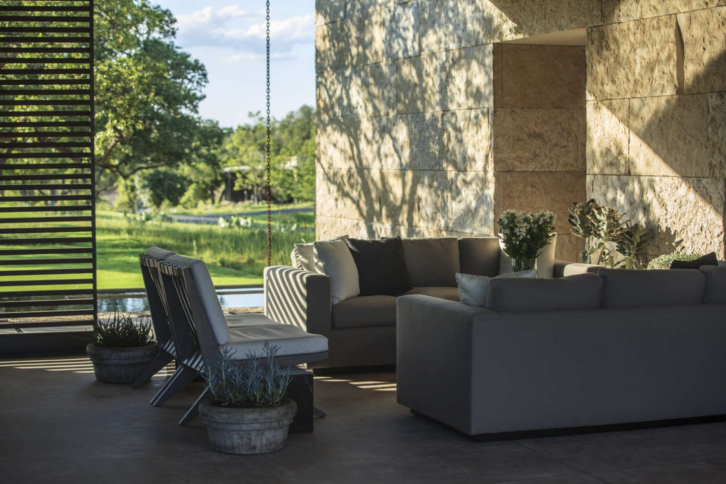 Eco-friendly rain chains, an alternative to traditional downspouts, add visual interest to the view from a covered patio.