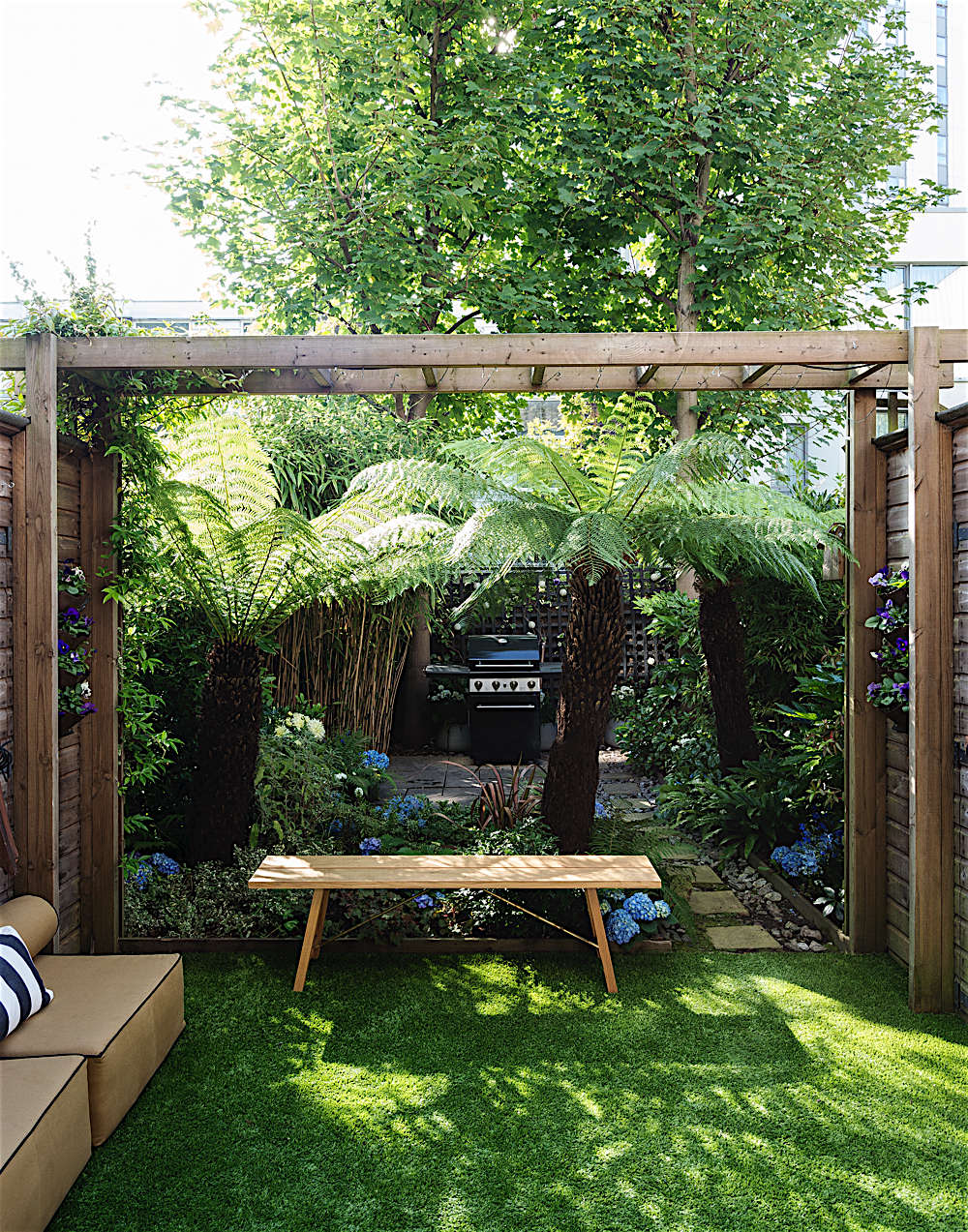 Another Country&#8\2\17;s Outdoor Bench \2 sits directly under the space-defining trellis and will weather to a silver gray patina.