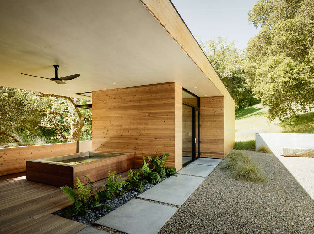 On the far side of the courtyard is a hot tub of Trainor&#8\2\17;s design, clad in batu wood. In this shaded spot, Trainor planted giant chain fern (Woodwardia). The door beyond opens into the guest house.