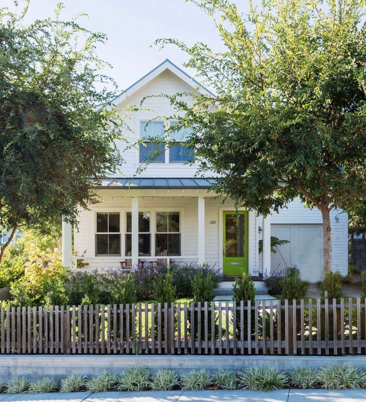 A picket fence built of \2-by-\2-inch pieces of clear cedar and a standing-seam metal roof are a nod to classic farmhouse style.