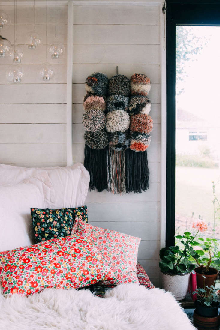 Jeska layered the daybed with colorful mix-and-match textiles, including pillows covered in floral Tana Lawn cotton fabric and a recycled wool throw. The interior paint is Bedec Eco Paint in white.