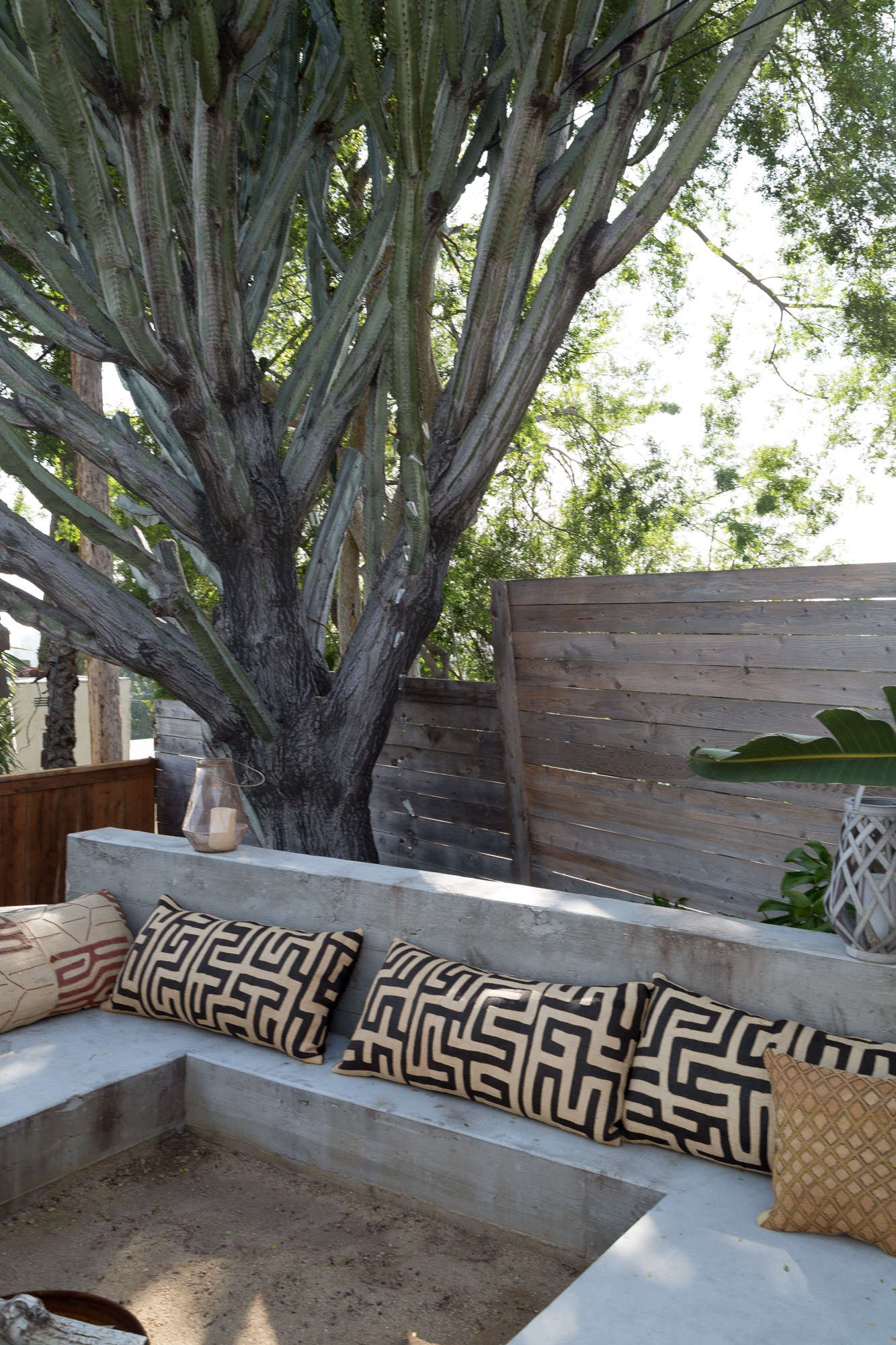 Behind the house: a low, poured-in-place concrete bench surrounds a sunken fire pit.