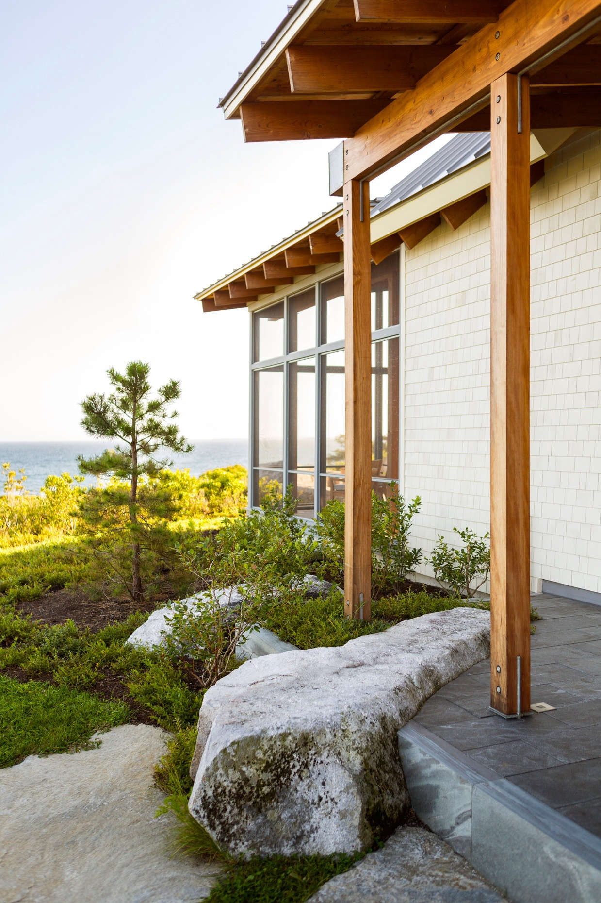 Richardson selected native shrubs, grasses, and wildflowers to blend the landscape with the existing meadows that stretch toward the shore. Here, lowbush blueberry wraps around wood posts.