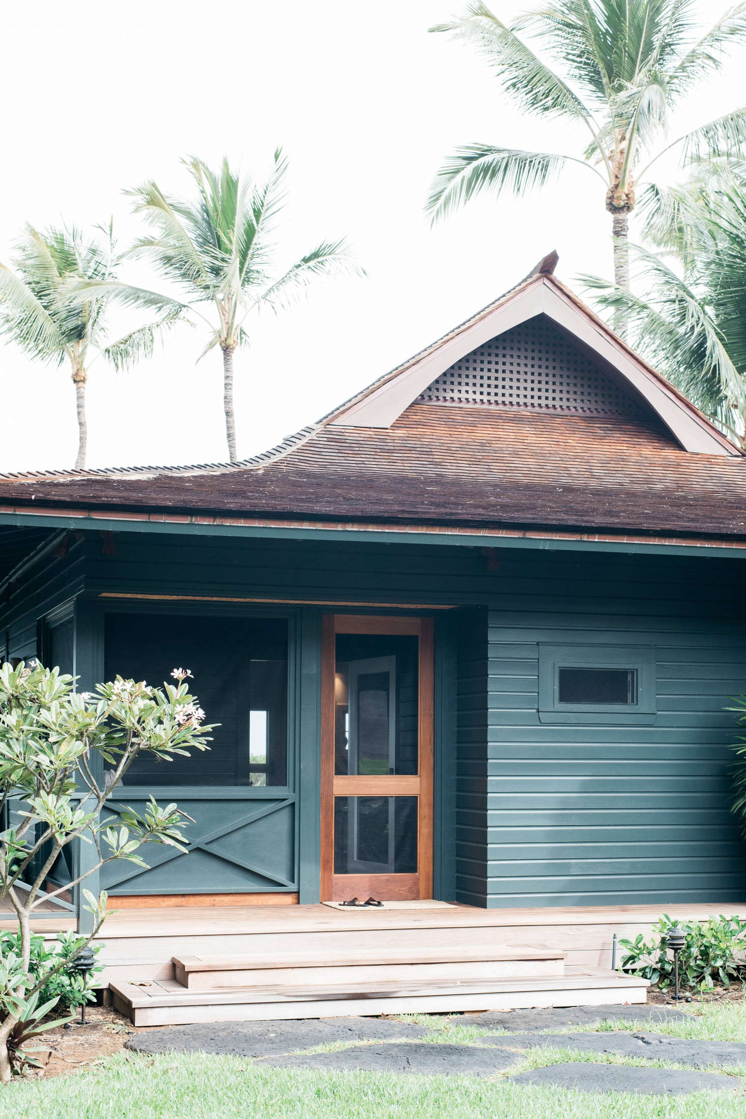 A a traditional plantation cottage, recently restored to its laid-back Hawaiian charm by Brooklyn-based architect Roberto Sosa, has a screened porch with a mahogany door. Photograph by Kate Holstein, from Vacation Rental: Maui Beach Cottage with a Tropical Garden.