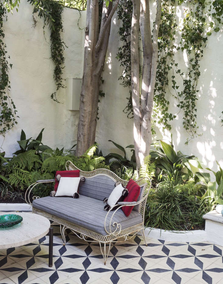 A vintage sofa with cushions upholstered with outdoor fabric will stand up to the elements in a Los Angeles courtyard.