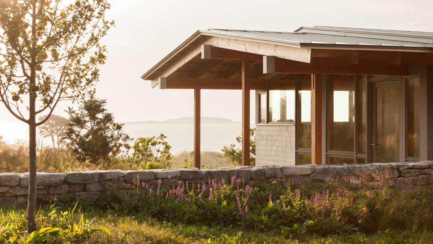 The house at twilight. The stone walls, open meadows, and apple trees recall the property
