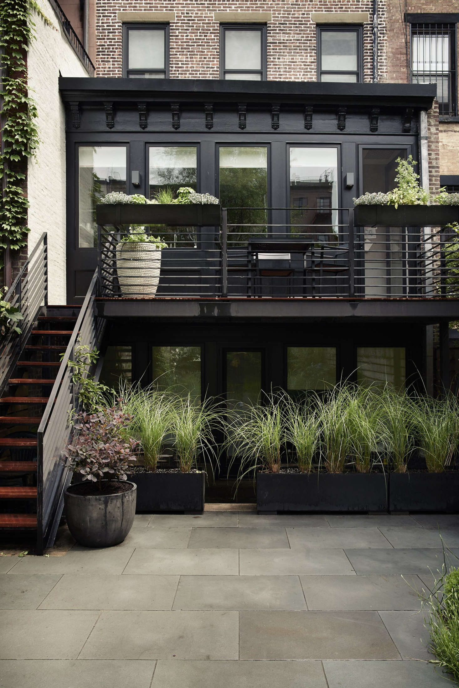 Photography by Pia Ulin courtesy of Bangia Agostinho Architecture. Lightweight fiberglass boxes planted with Miscanthus sinensis ‘Morning Light’ for soft screening provide privacy for both tenants and landlords in a Brooklyn townhouse garden. For more, see Before & After: A Modern Townhouse Garden in Brooklyn.
