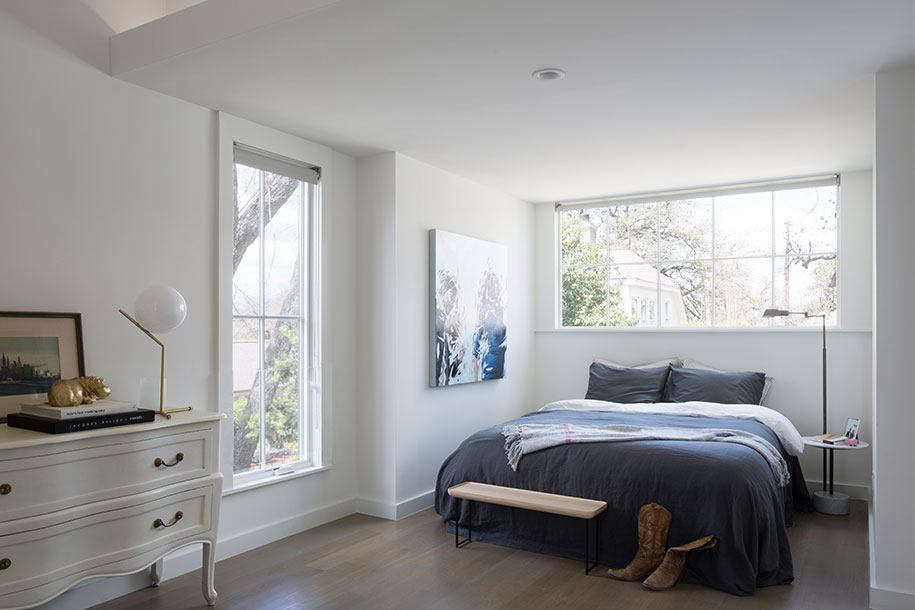 A garage turned guest house has a bedroom alcove with a dormer window (above the bed) which mimics and size and shape of a kitchen window in the main house. Photograph courtesy of Tim Cuppett Architects.