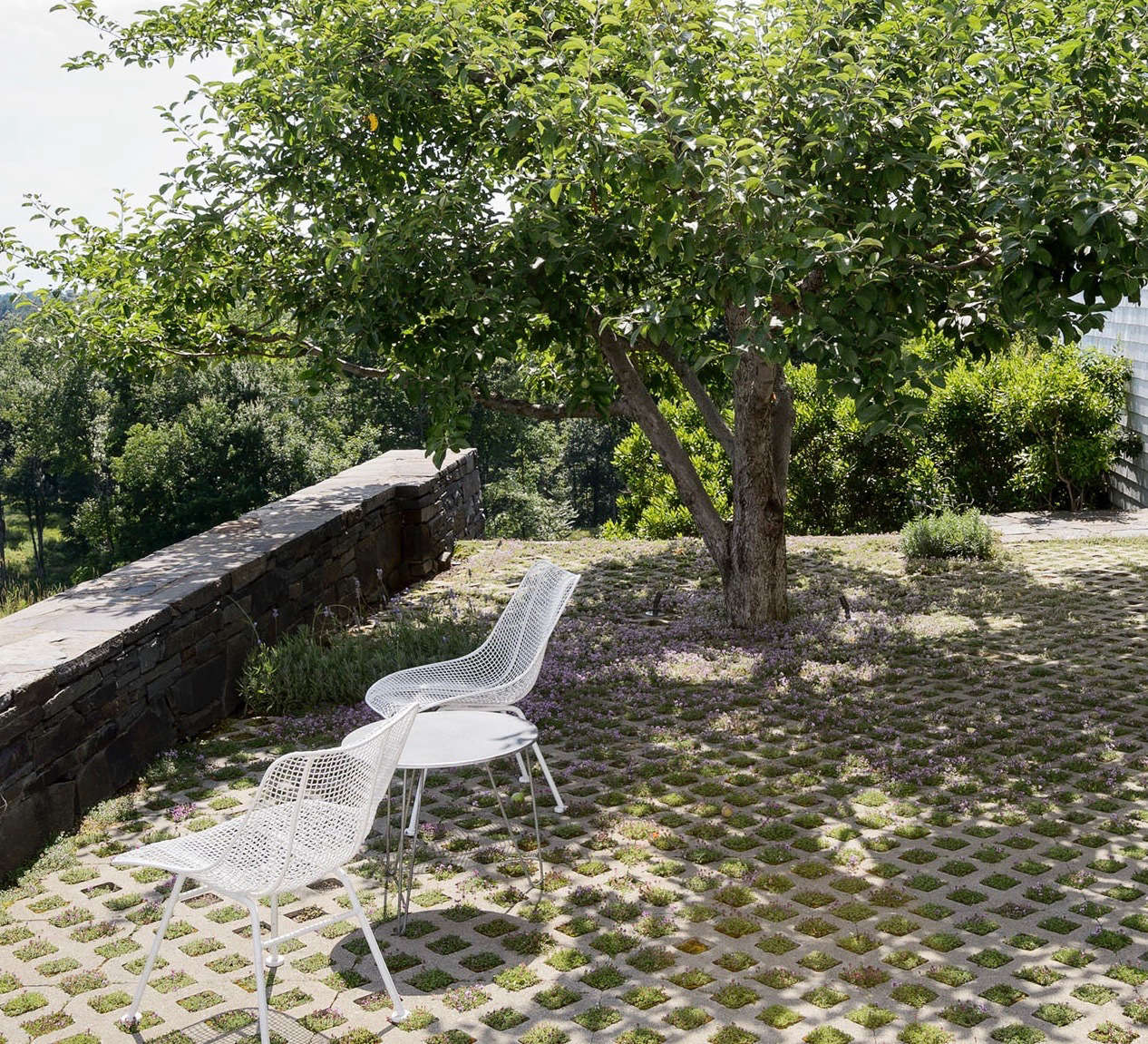 Architect Steven Harris and landscape designer Lucien Rees Roberts have been collecting vintage Woodard chairs for years, giving them a home on their thyme terrace in Kinderhook, New York. Photograph by Matthew Williams.