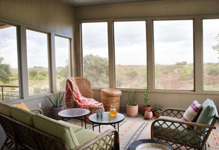 Austin-based interior designer Ann Edgerton designed a screened porch with a soft bohemian look using vintage rattan furniture, Moroccan accents, and bright textiles. “I wanted to create a place you can grow into with new textiles and plants,” she says. Photograph by Molly Winters courtesy of Ann Edgerton, from Steal This Look: A Bohemian Screened Porch in Texas.