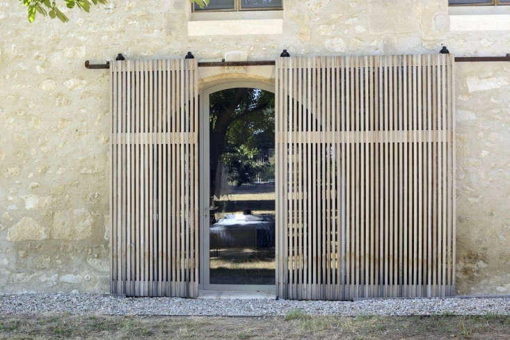 Cedar sliding screens filter in light in a restored farmhouse in Les Baux de Provence, a \15-minute drive from Arles. See more in The New Provencal Style: An Artfully Reinvented French Mas on Remodelista. Photograph by Katrin Vierkant courtesy of LSL Architects.