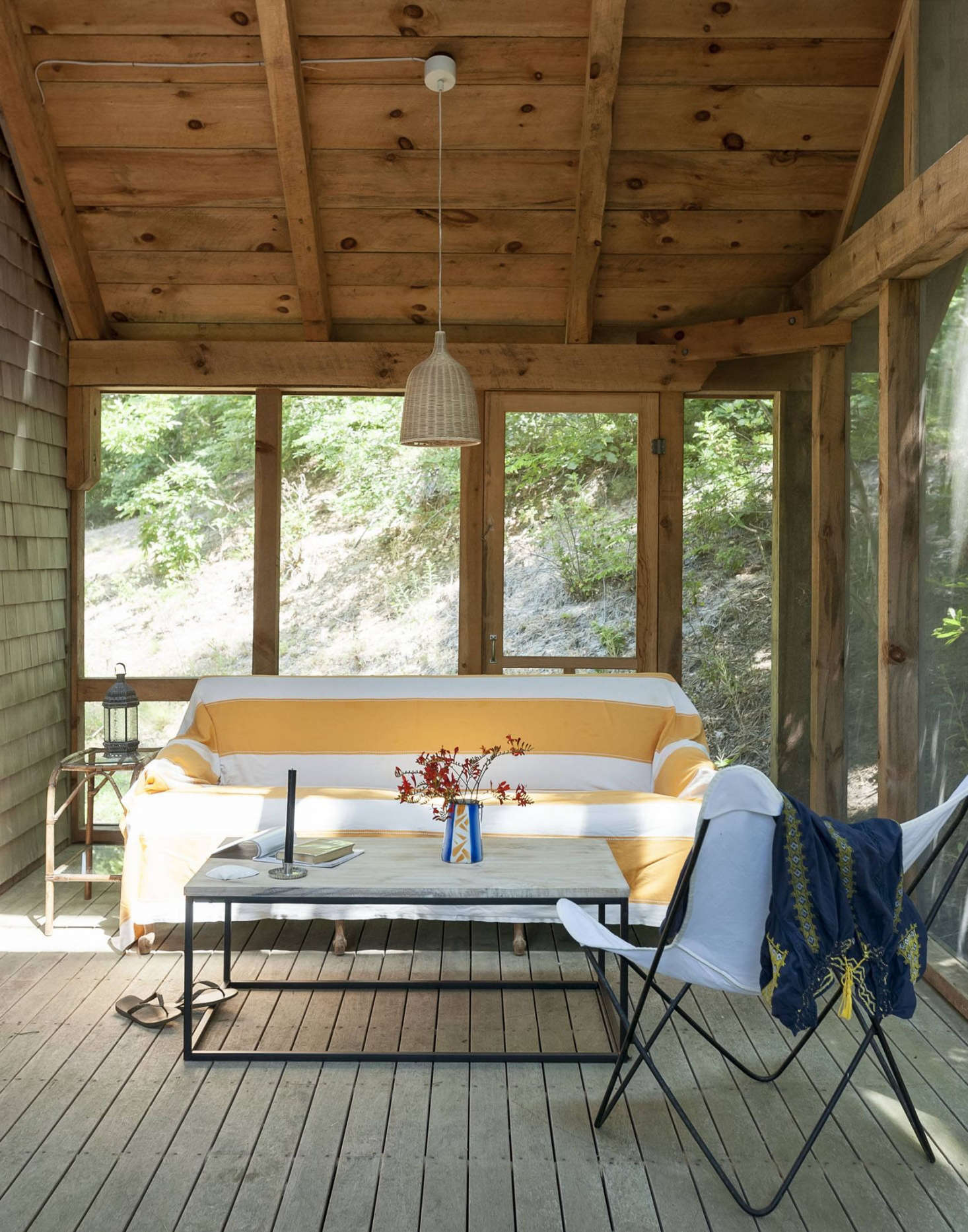 A simple timber frame screened porch is an homage to a nearby Cape Cod house built by homeowner Miranda Heller