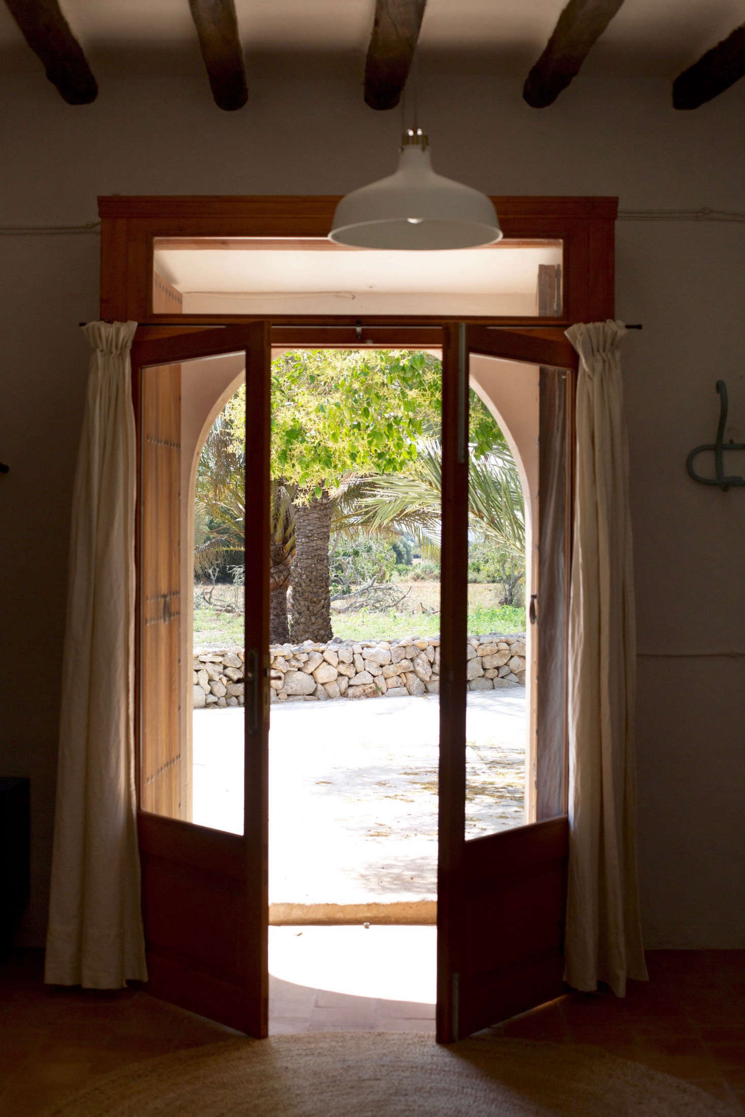 Low stone walls overlook farmland and frame views of a distant mountain. Nearby are stables where guests can ride horses (their names are Pelusa And Turó).