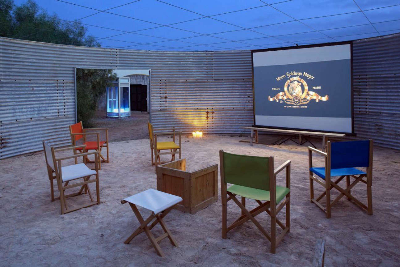An old water tank is now a sandy-floored outdoor movie theater.