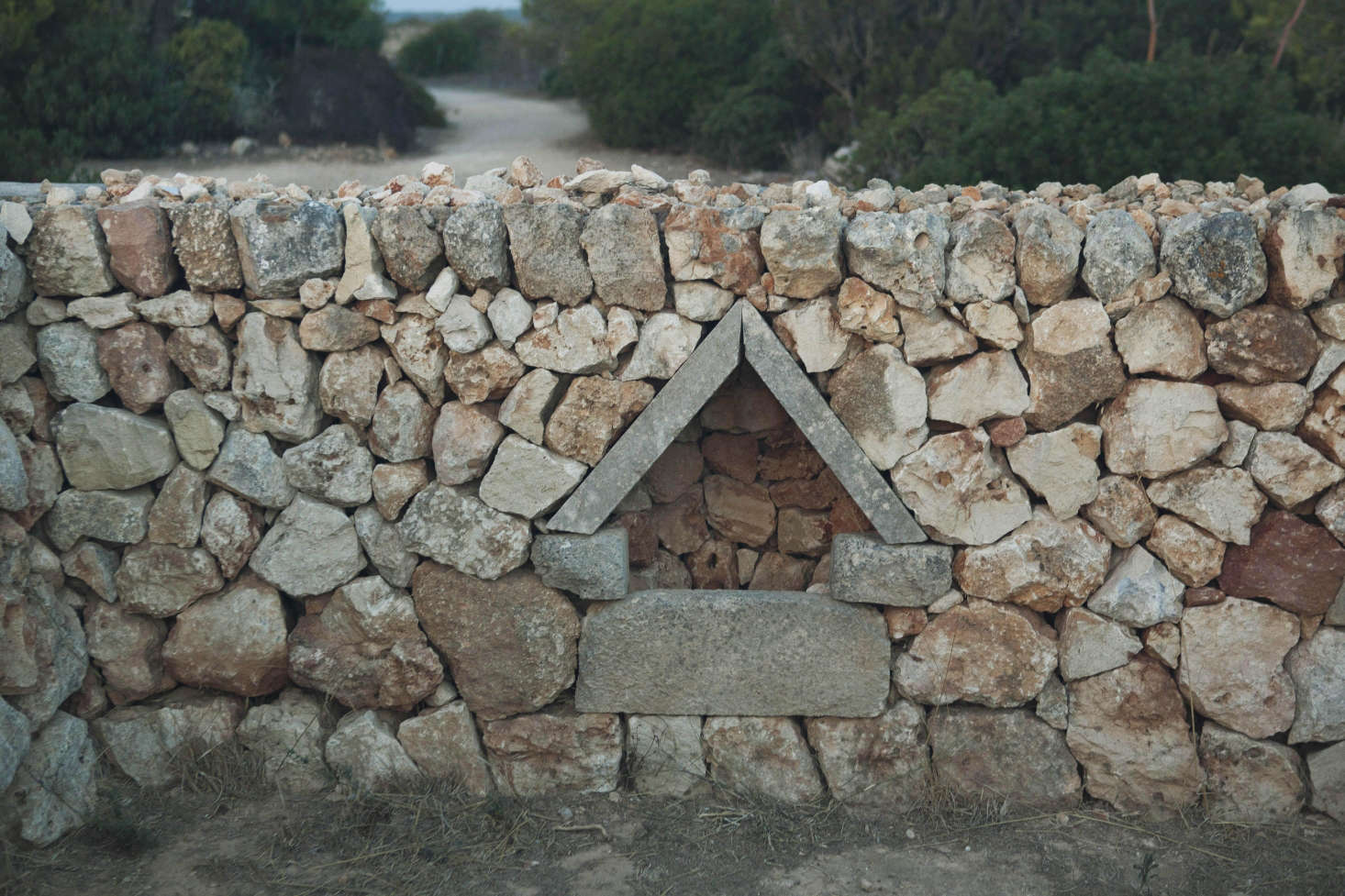 A traditional agricultural design used for feeding animals; a bowl would be placed within this shaded, protected nook.