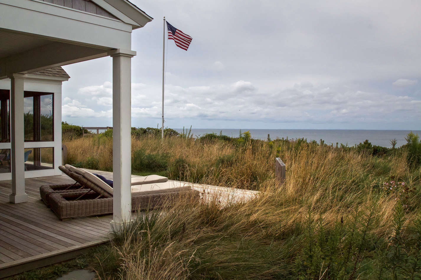 The continuous porches along the bay side are completely engulfed in a sea of grass.