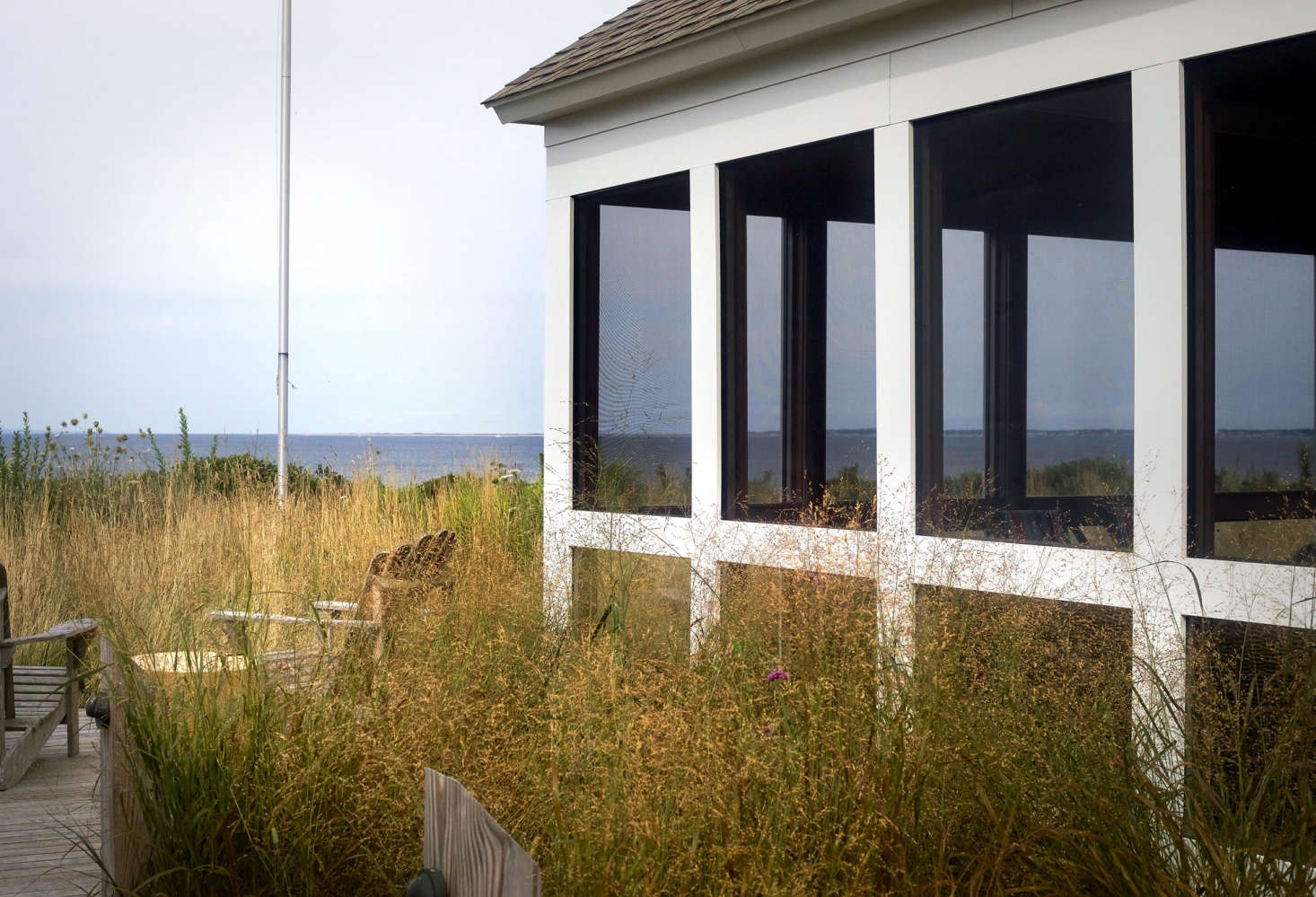 Generous windows on this side of the house take in the view of the meadow and bay beyond, merging the indoors with the outside.