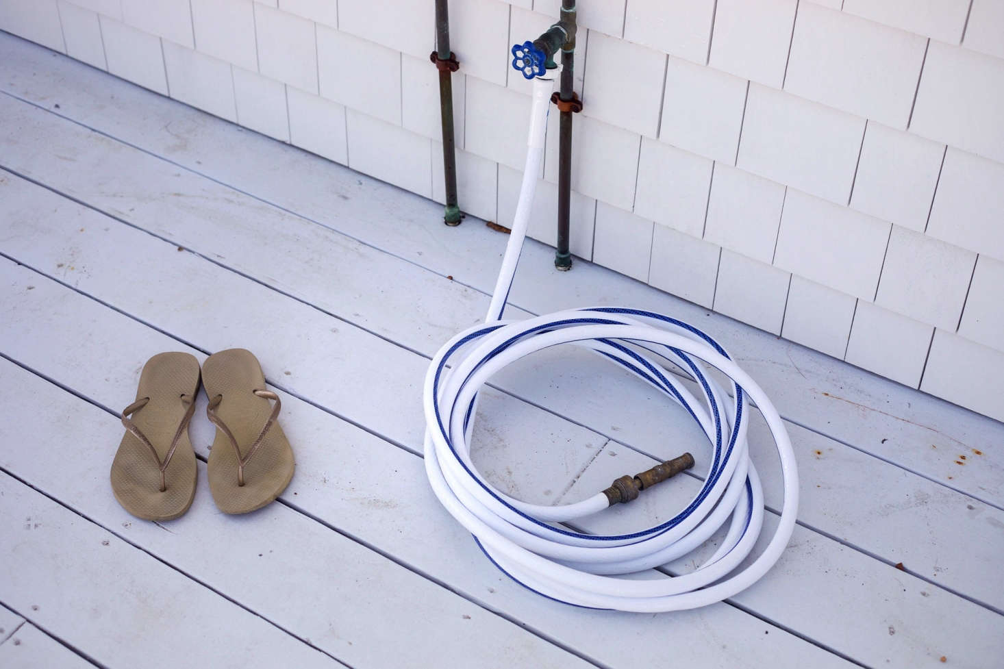 No space for an outdoor shower? A simple hose will do for rinsing grass cuttings from feet. Or, place a shallow bucket full of water beside the door for a quick dip. Photograph from Shipshape Cape Cod Cottage Inspired by Wes Anderson’s “The Life Aquatic