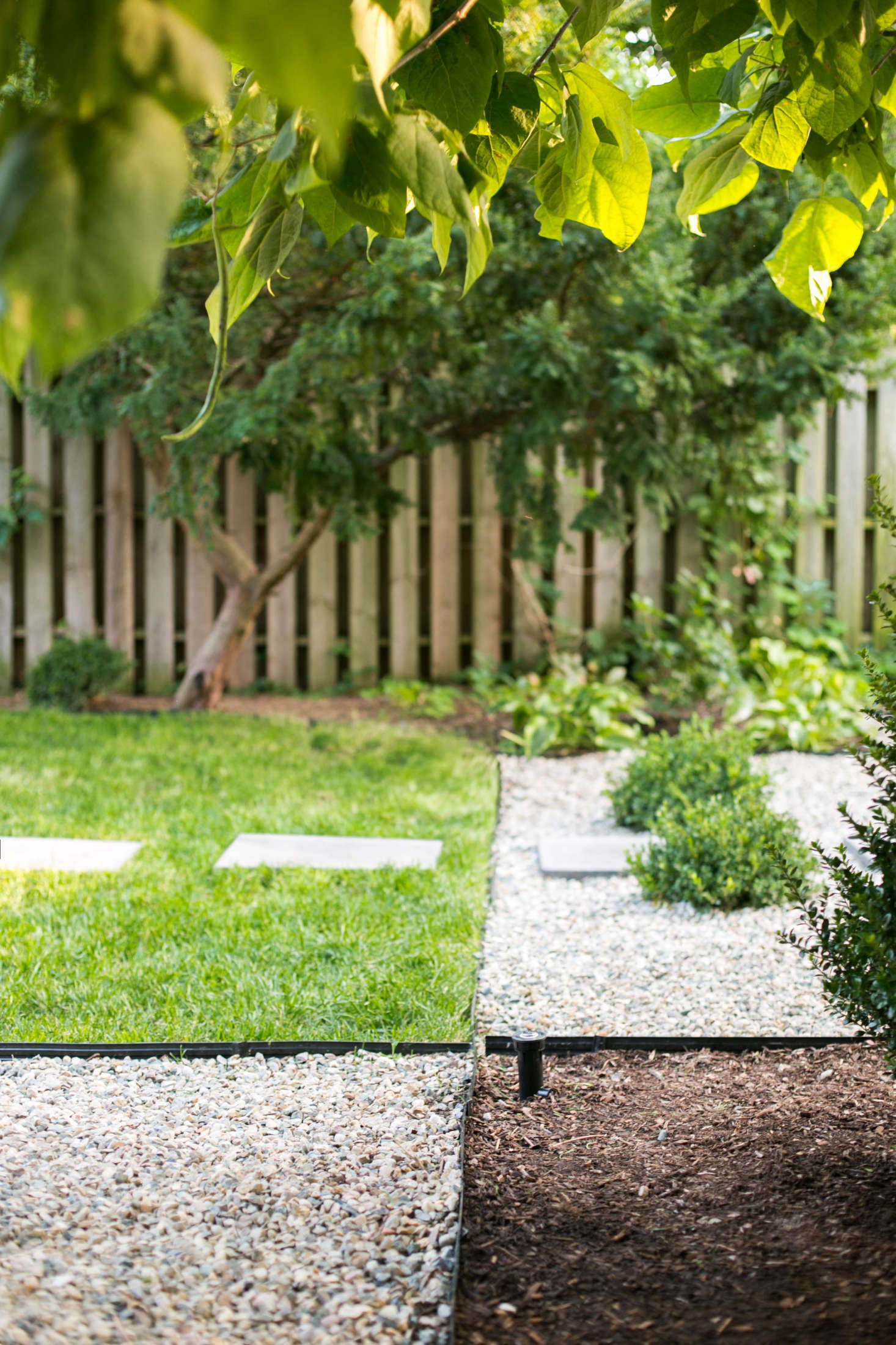 Contractor Packard came up with a landscape design that integrated turf grass (for the dogs to play), gravel (to edge pathways, and mulch (as ground cover beneath shrubs and other plants).