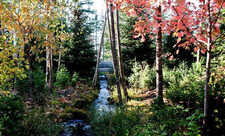 A granite bridge capable of supporting vehicles spans a restored stream. &#8\2\20;A gravel entry drive crosses the restored stream over a new granite bridge. The dwellings are one-story from the road, embedded in a grove of red maples and native birches,&#8\2\2\1; says Stimson.