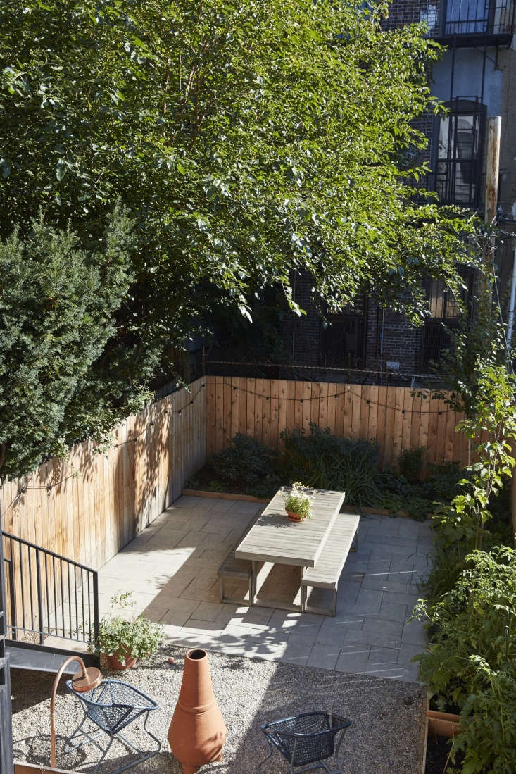 Permeable paving of bluestone pavers and gravel is pale against the western red cedar fence.