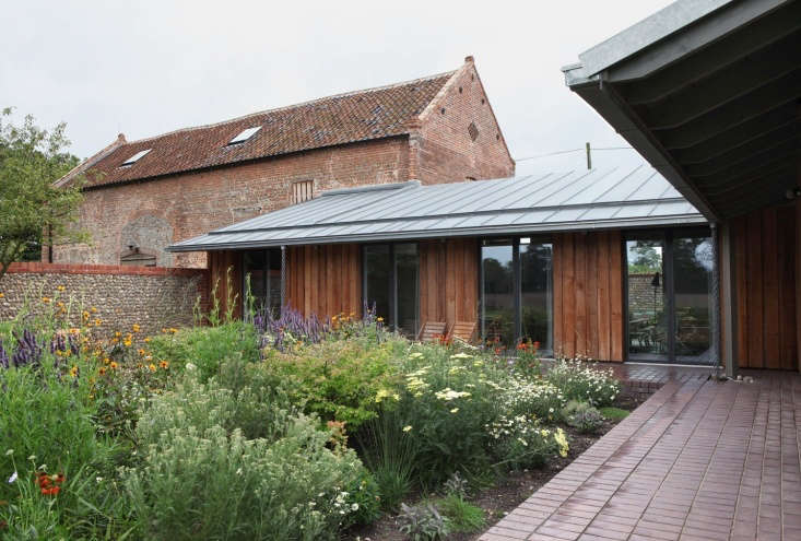 : A view of one of the two inner courtyards, formed by the connection of the tithe barn (L) and the piggery (R). Photograph by Ioana Marinescu. See more in A Rural Remodel in Norfolk, Tithe Barn and Piggery Included.