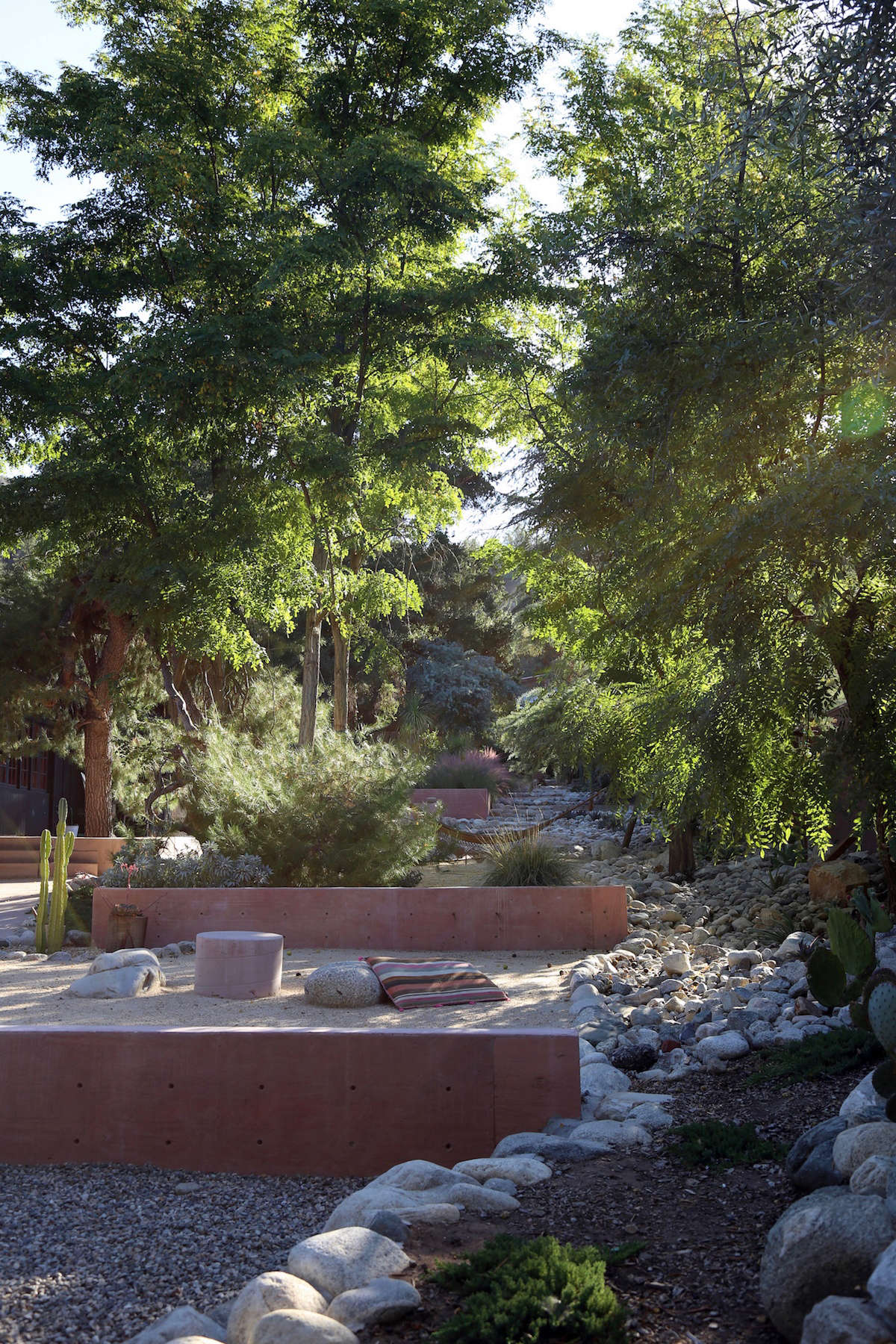 The Morgans created a rock river along one side of the garden, composed of small boulders they collected over time. The largest stones, including those used as seating around the small pink concrete table shown above, are from Southwest Boulder & Stone.