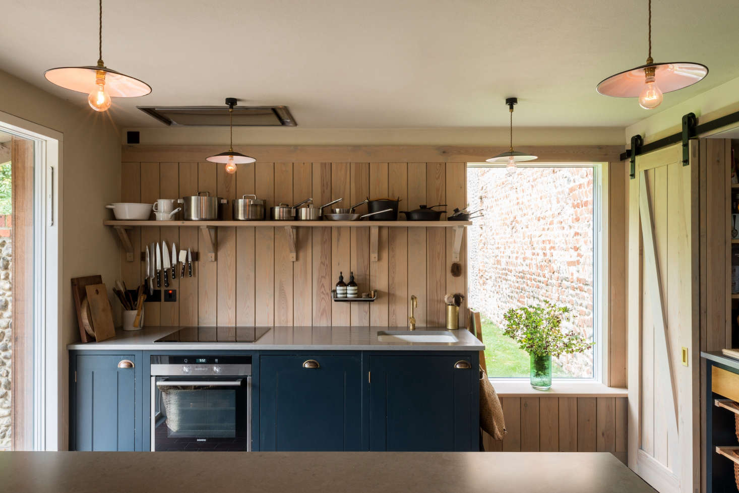 Generously sized windows and French doors open the kitchen to the garden.