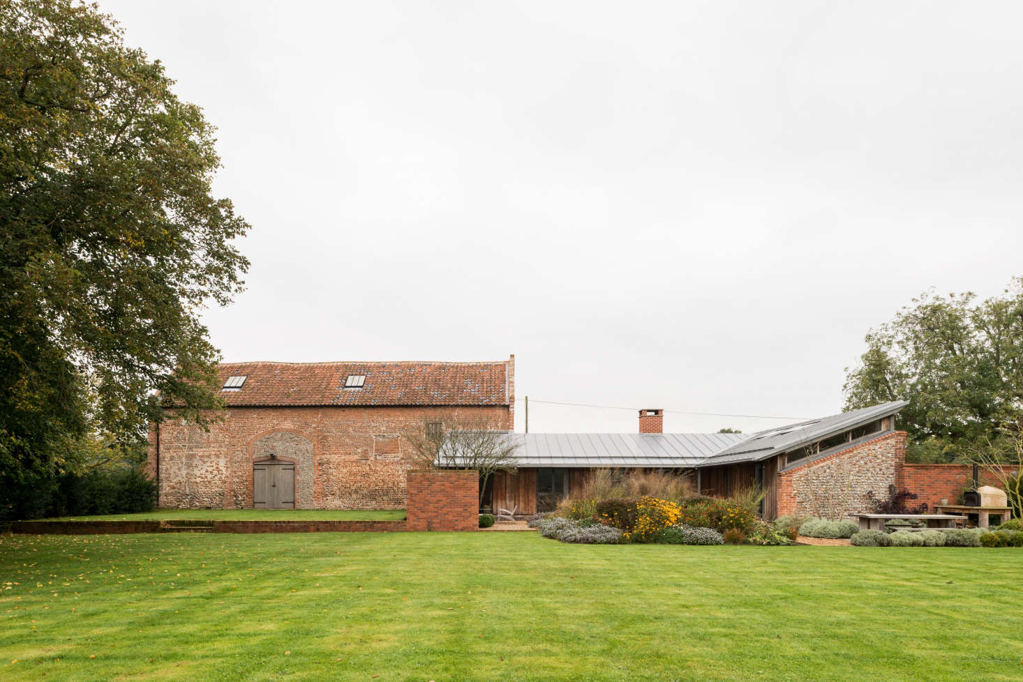 The building on the left is an old tithe barn, where in centuries past the local clergy stored the taxes they collected from surrounding villages. At right is the remodeled piggery, in which Erlam and her husband and two children live.