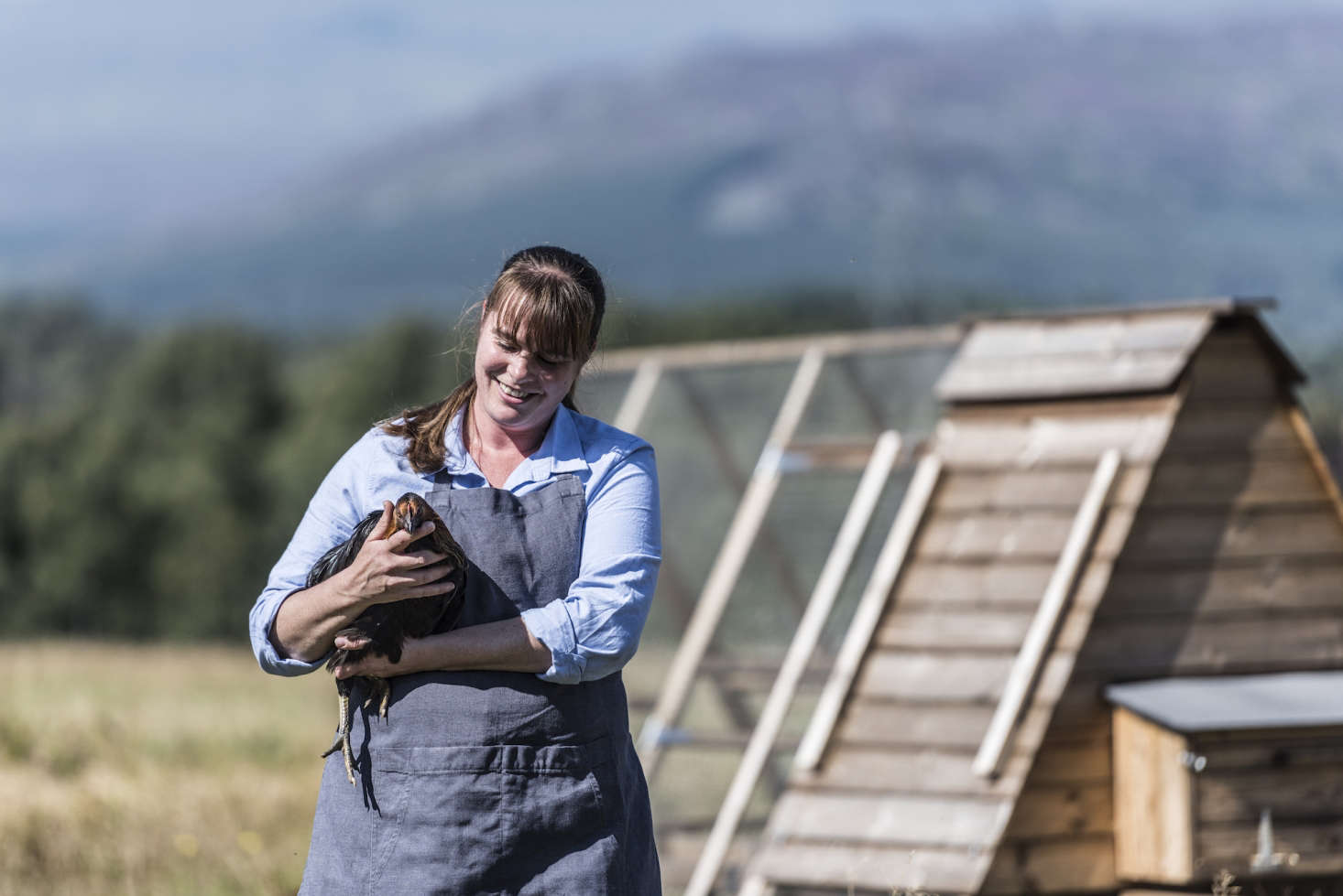 A farmer with an egg-laying hen.