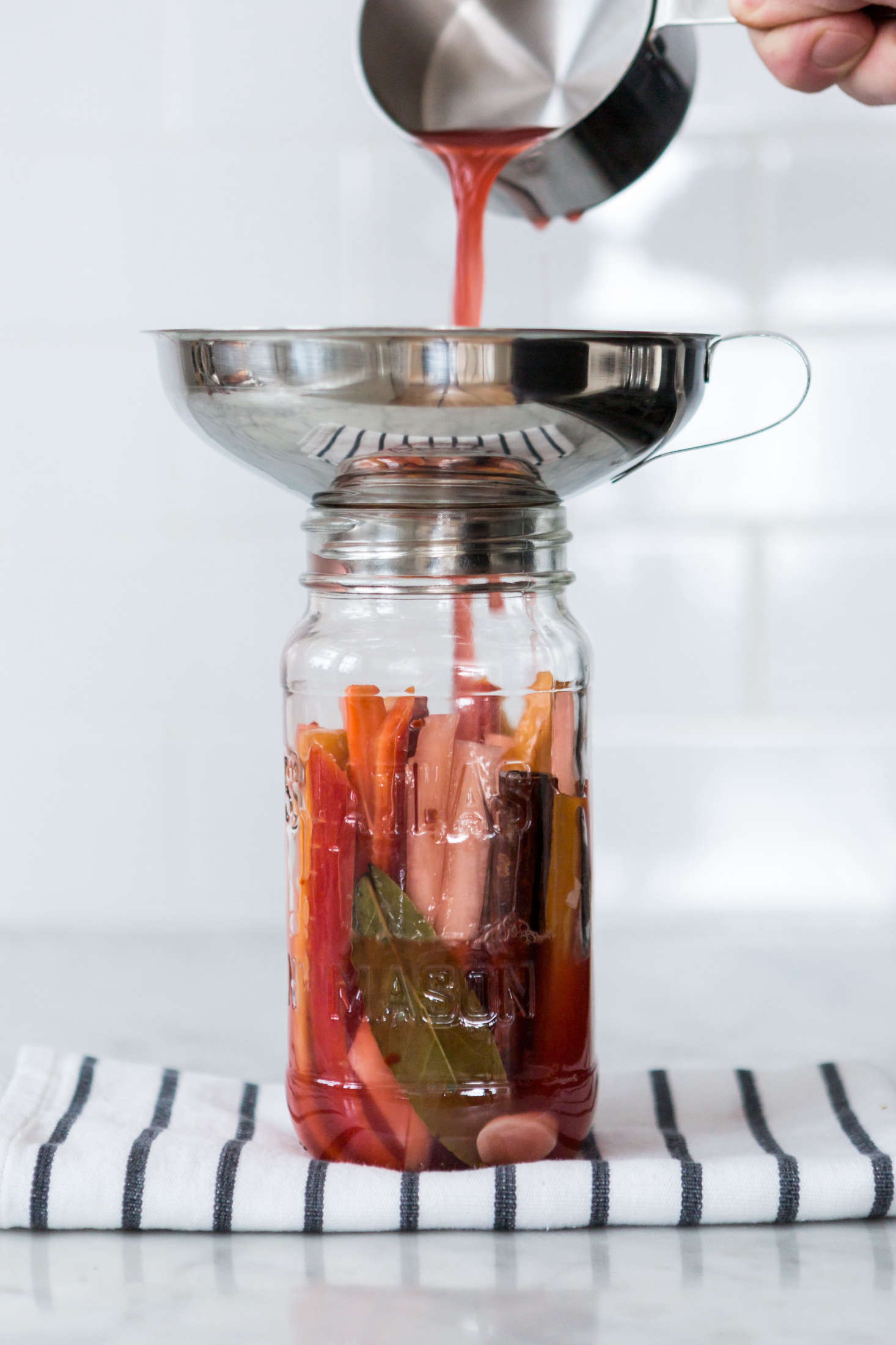 “Use a funnel, some tongs, a slotted spoon, and a measuring cup to transfer the vegetables, spices, and brine,” Sean says. “Yes, you could do without one or two of these tools, but they make it a lot easier to fill your jars without any messy kitchen incidents that waste hours’ worth of work or leave permanent scars.”