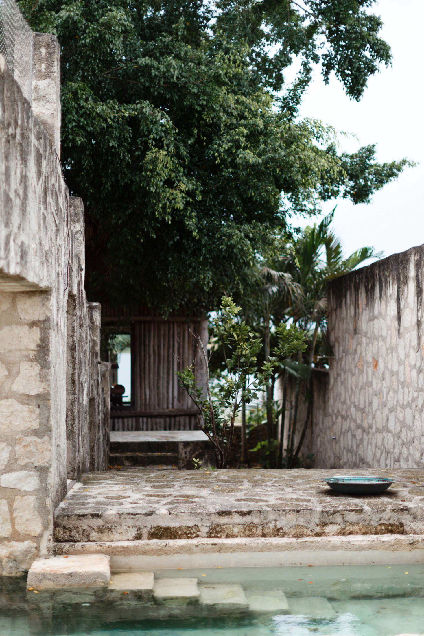 One of two green plunge pools is sheltered by limestone walls and archways, adding privacy—and the distinct feeling that it has been there since Mayan times.