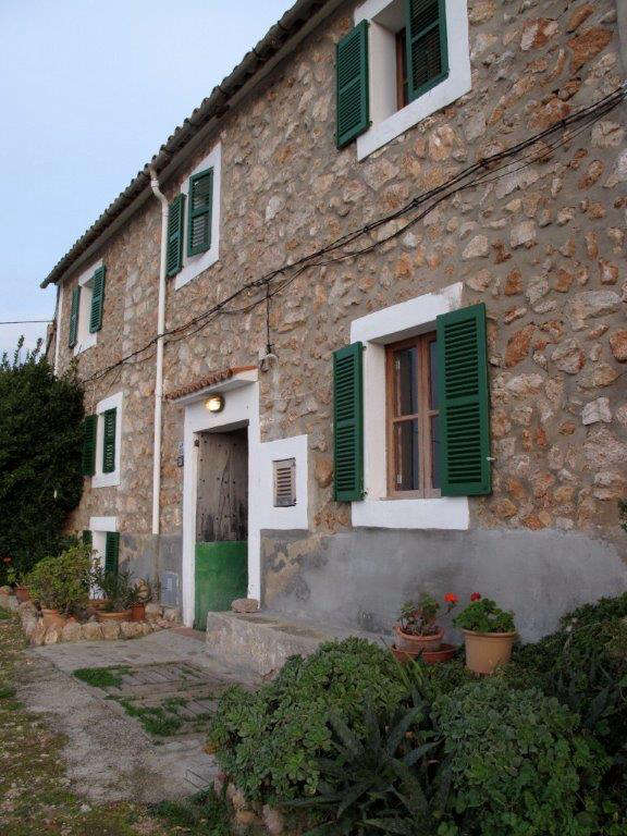 The exterior, before, with less-than-bright shutters, a potted garden that felt hemmed-in by a rock border, the small patio, overgrown with weeds, and nowhere to sit and enjoy the view.