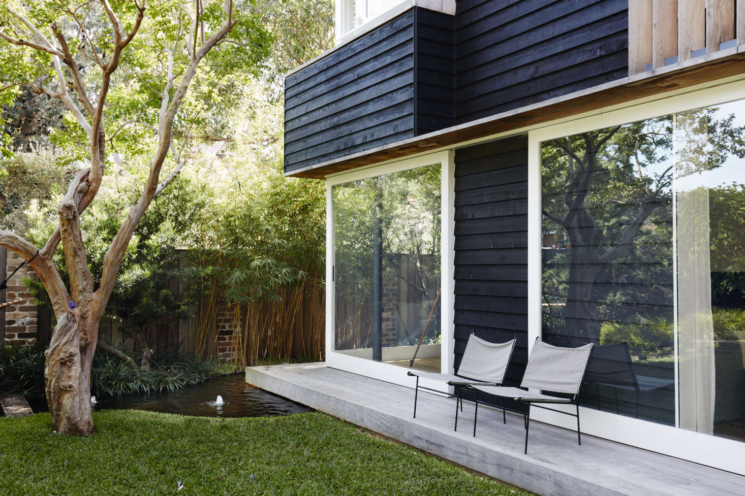 A narrow back deck serves as a step to the garden, and a perch for chairs when entertaining. It