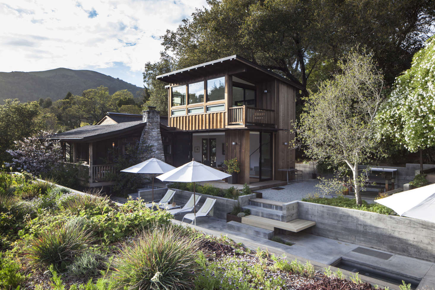 The view of the house from the roof of the new garage. The original home, at left, has siding of old-growth redwood and an exterior chimney made of local Sonoma stone.