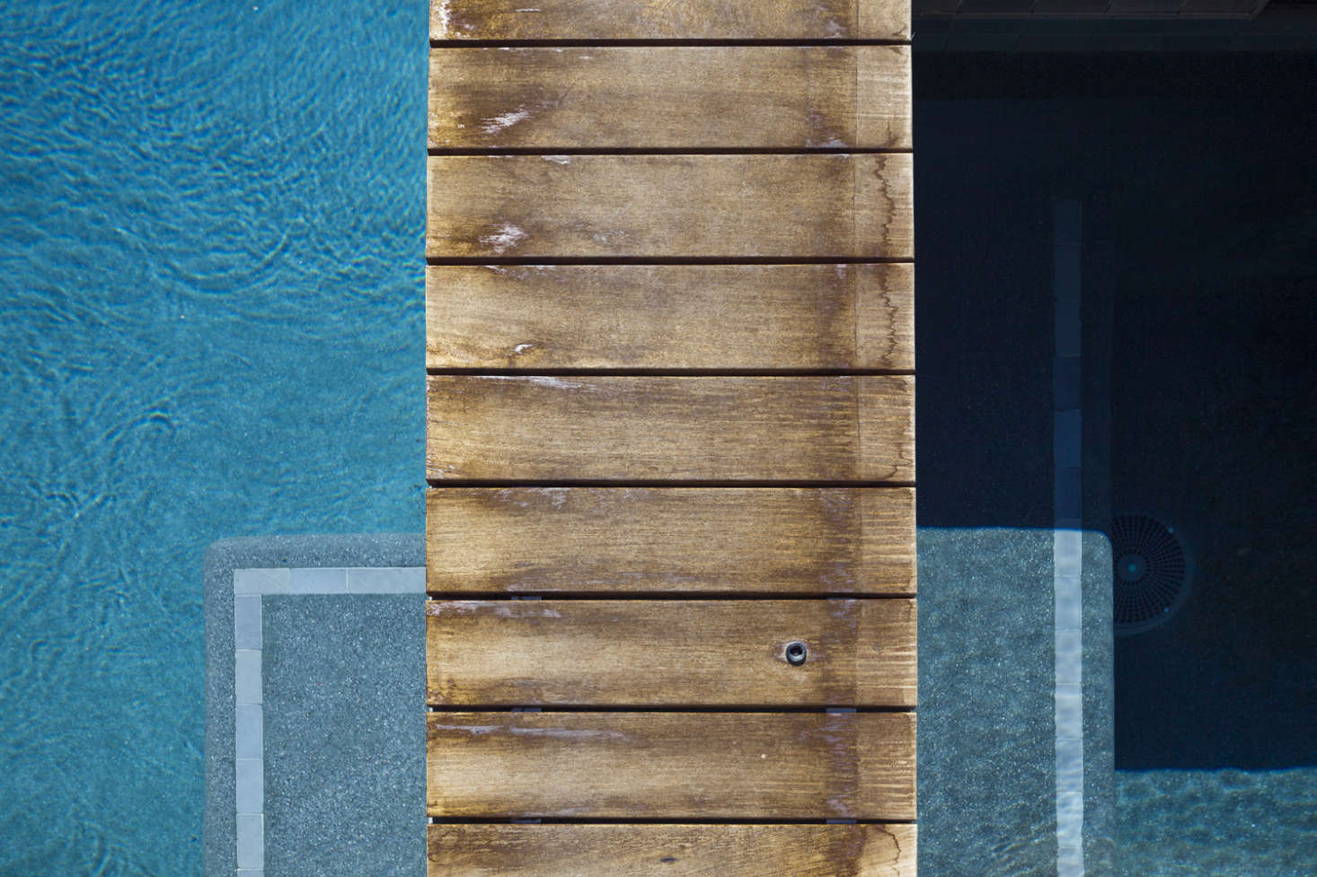 The pool and its sunken benches are lined in pale gray cement tile.