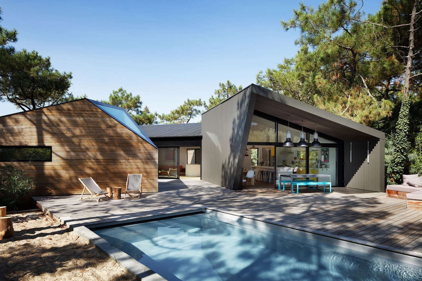 The pool has a plinth at one end for lounging and an integrated pool cover opposite.
