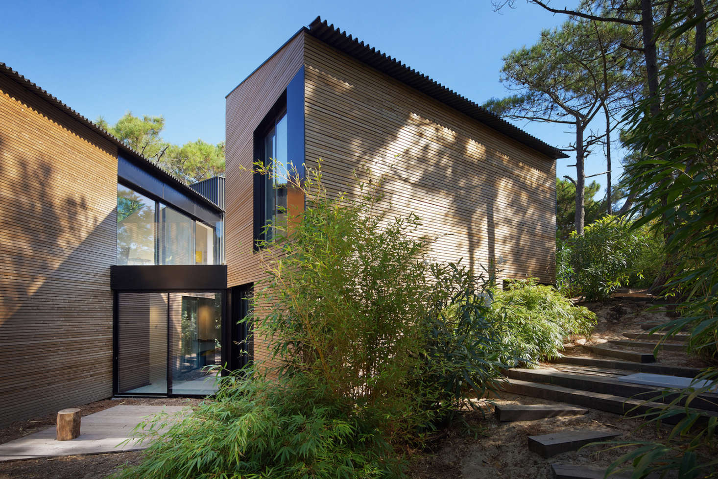 Several free-form wooden stairways crisscross the property, linking the entrance to the pool deck.