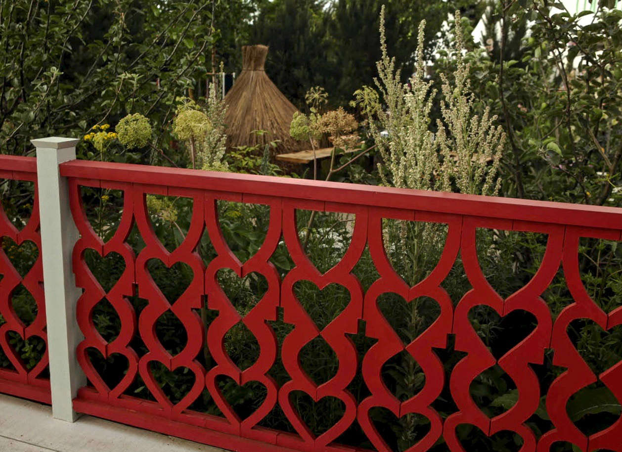 A gaily painted fretwork fence, reminiscent of the wooden designs that decorate older dachas.
