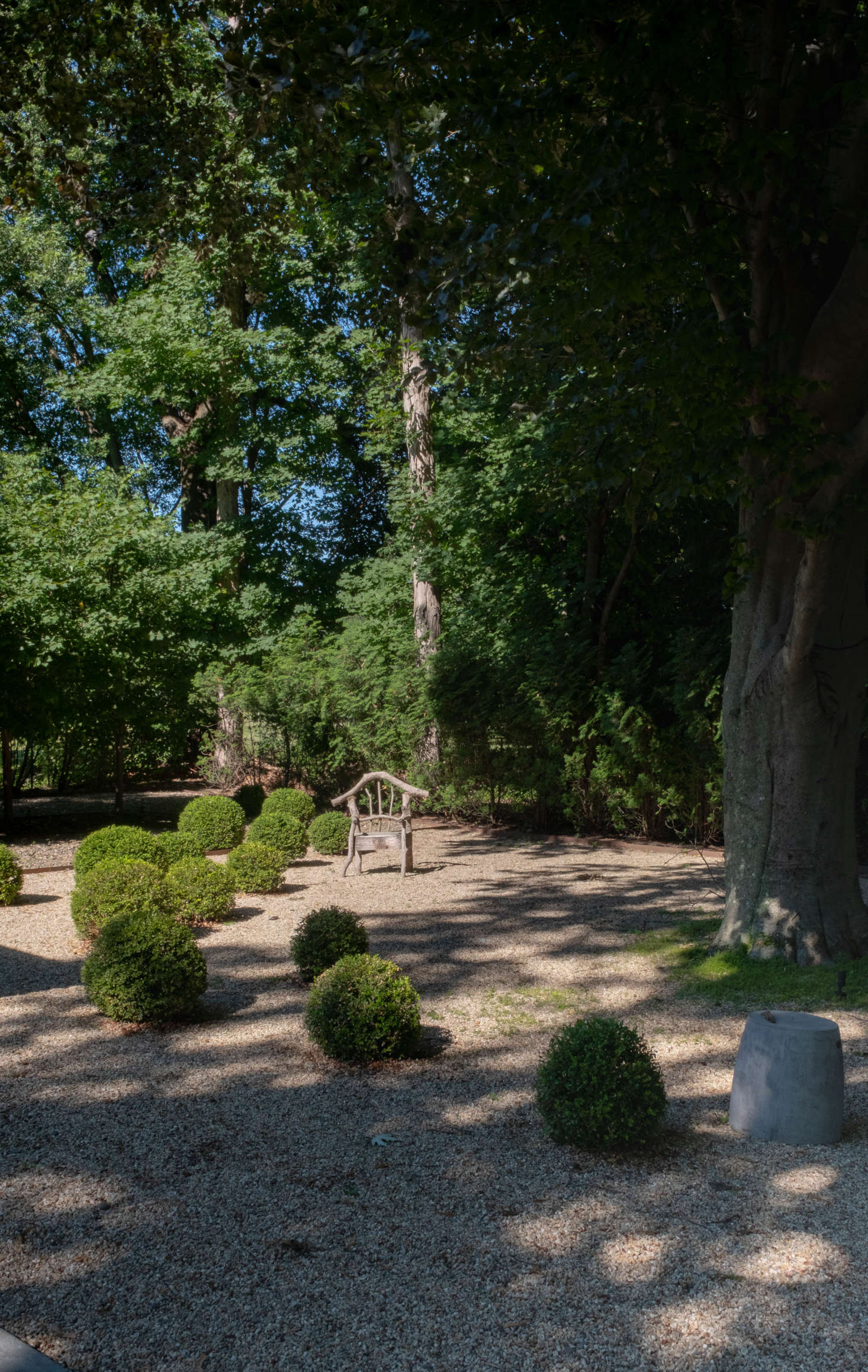 A moment of whimsy: spherical boxwoods dotted around the grounds, and a driftwood chair, left behind by the previous owner. 