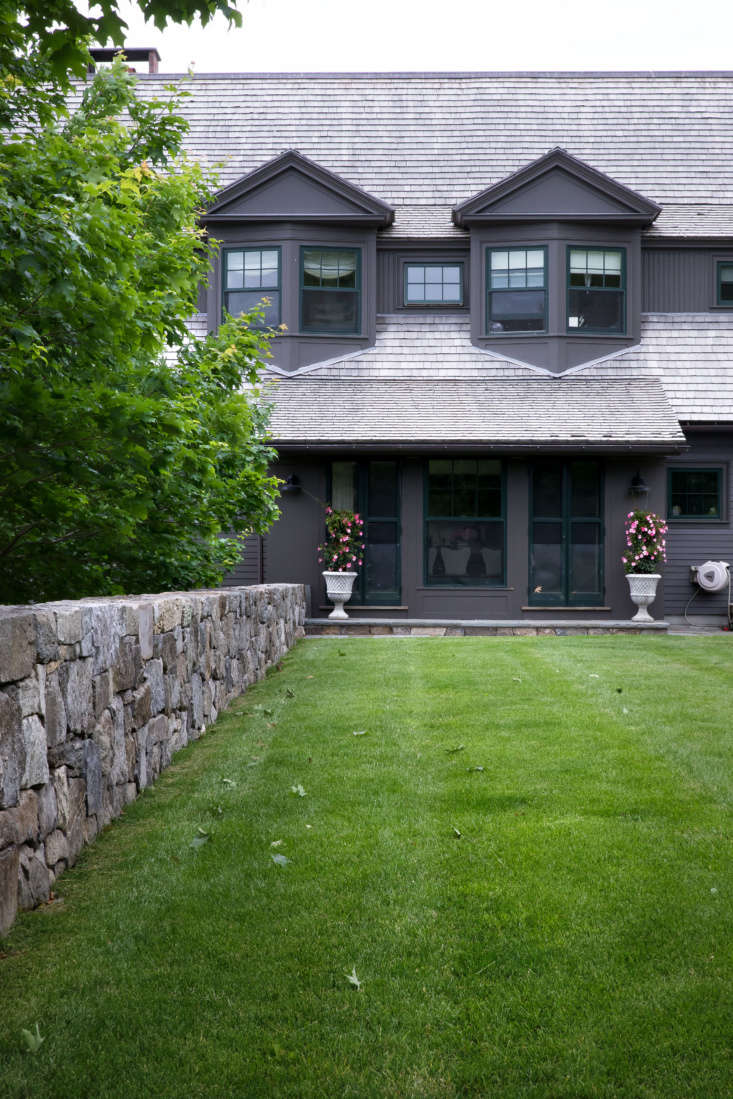 In front of the shingle-style house built by Albert, Righter & Tittman Architects, a line of sugar maple trees and another newly built fieldstone wall shelter a generous lawn, the main outdoor living and recreation space.