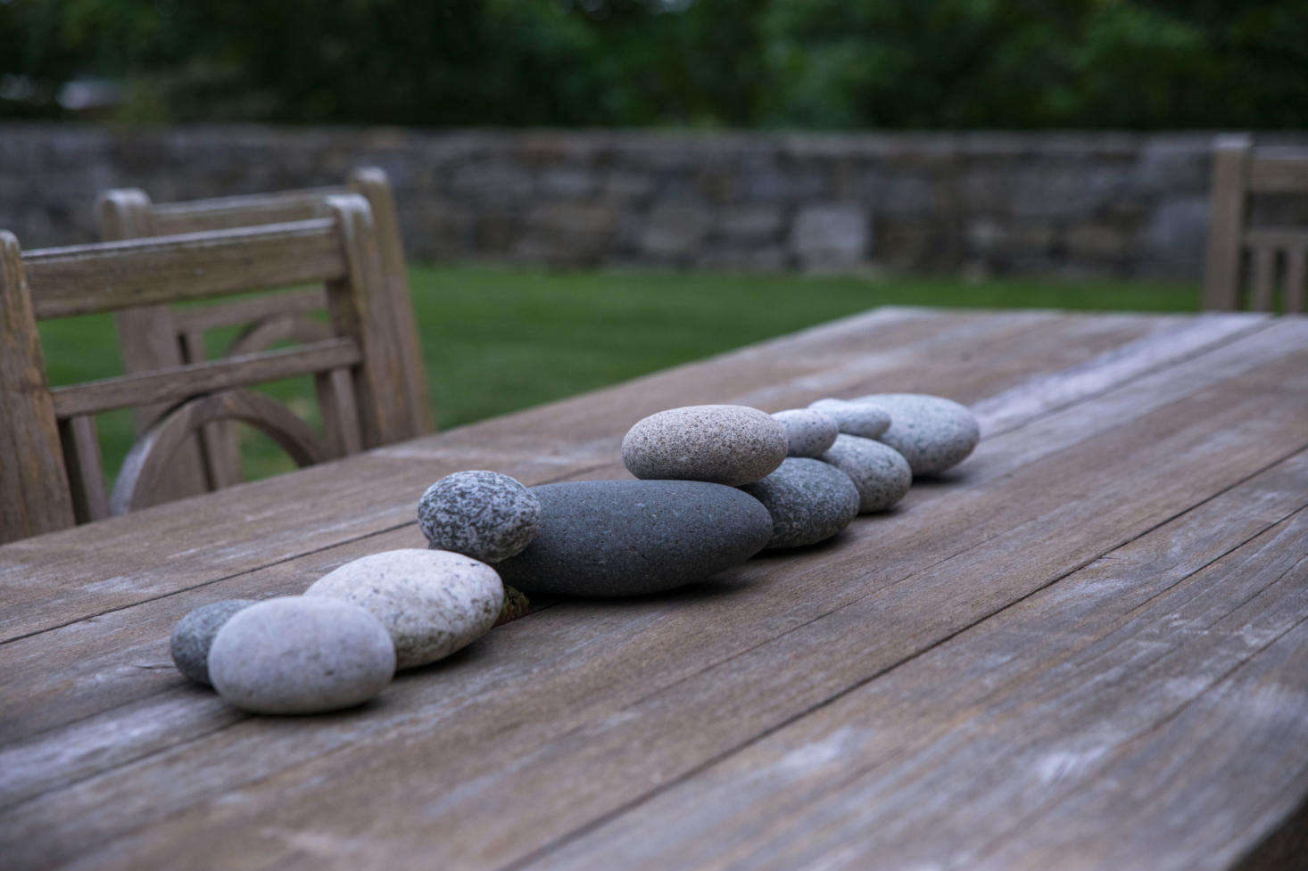 The outdoor dining table features a somewhat more loosely constructed stone wall of its own.