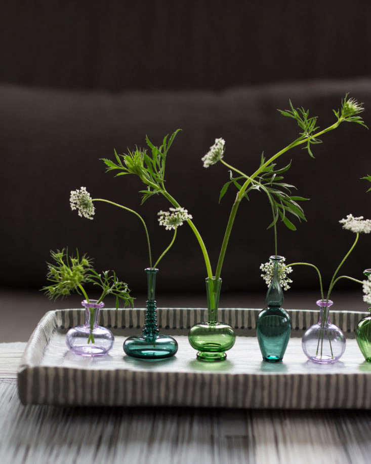 Handblown miniature vases from Kiva Ford each hold a stem of Queen Anne&#8\2\17;s lace. For similar vases, consider a Handblown Vase in Gray; \$\160 via Etsy.