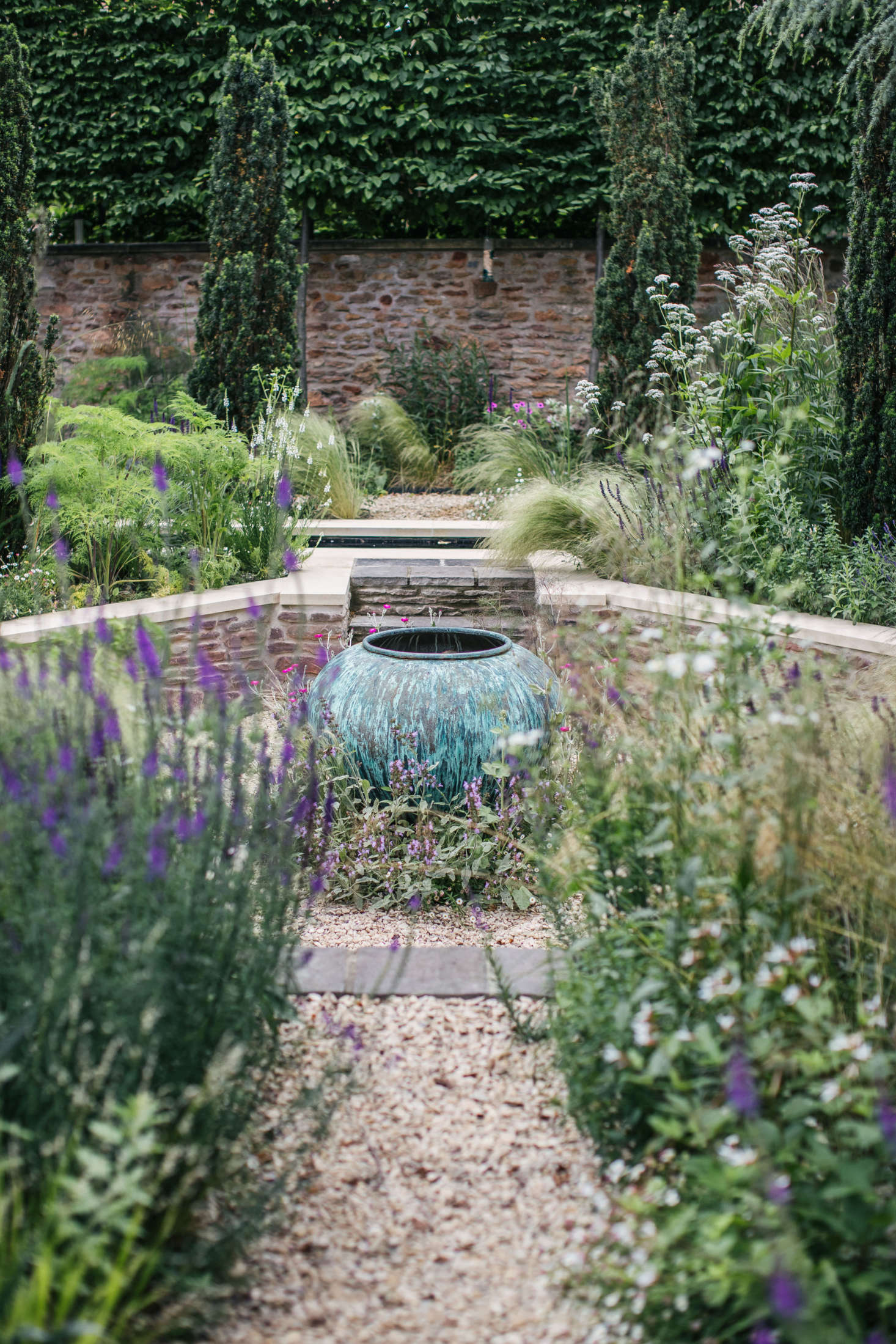 An antique urn is a focal point in the garden. For more inspiration, see Landscaping: 8 Ideas to Add Antiques Artfully to Any Garden.
