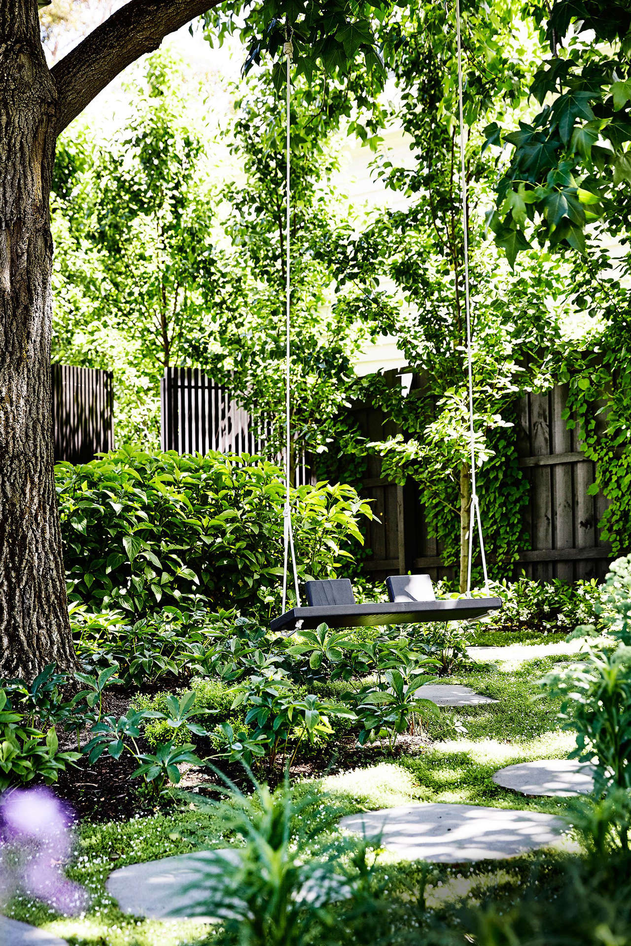 Bluestone pavers lead to a handmade garden swing, tucked into a shady corner.