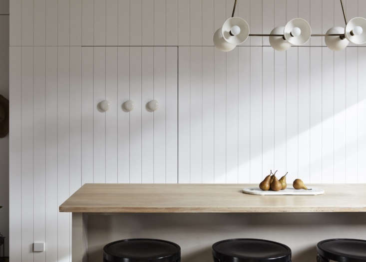 Painted in in Dulux’s Lexicon Quarter, wood paneling adds texture in a kitchen in Melbourne, designed by  Carole Whiting Interiors Design. Photograph by Jack Shelton.