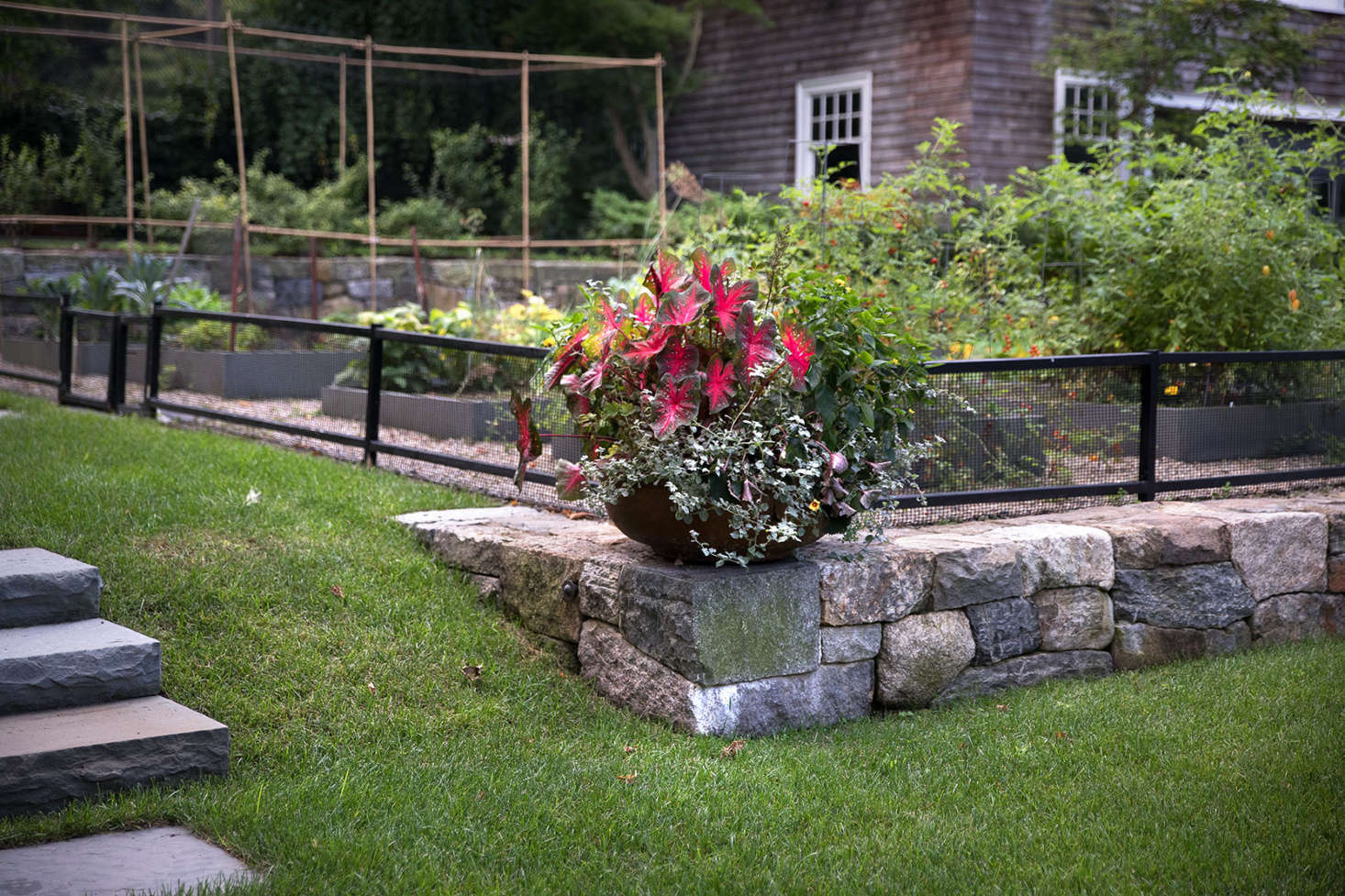 Though most of the property is planted with natives and perennials, a planter provides a space for some colorful annuals.